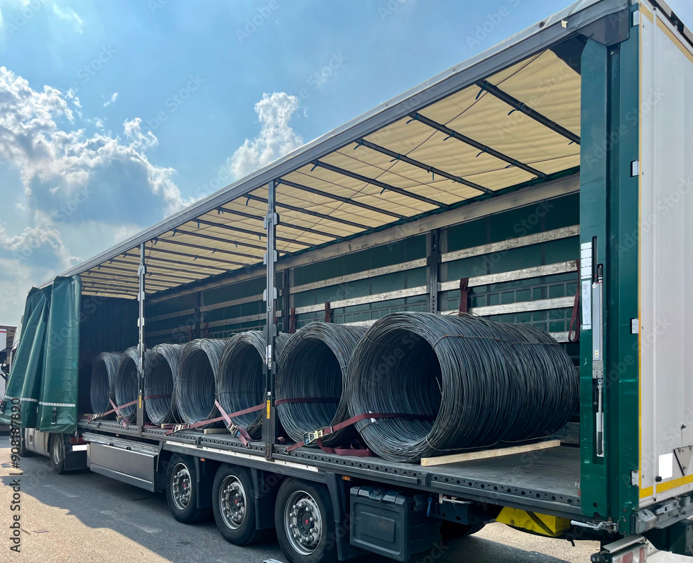 An open semi-trailer truck carrying metal wire. Industrial logistics and transportation of goods An open semi-trailer truck carrying metal wire. Industrial logistics and transportation of goods