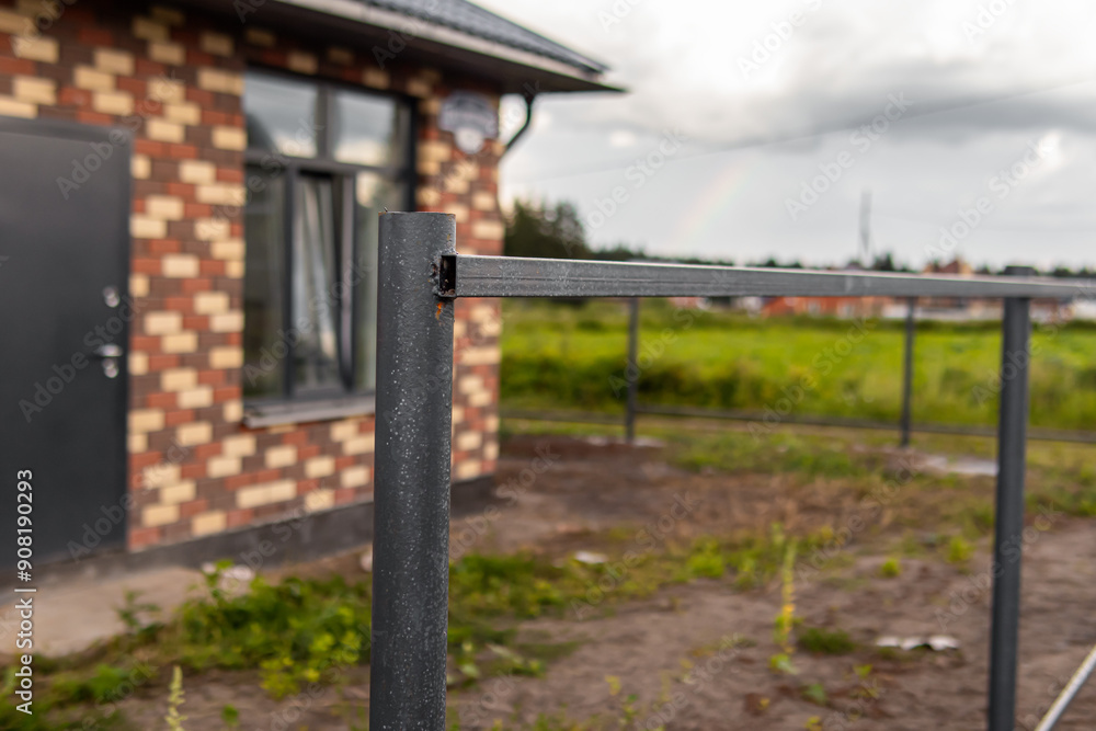 Dark gray metal fence posts. Posts and and lintels. Installing fence in country house Dark gray metal fence posts. Posts and and lintels. Installing fence in country house