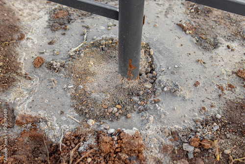 Installation of metal fence. Concrete filling of fence posts