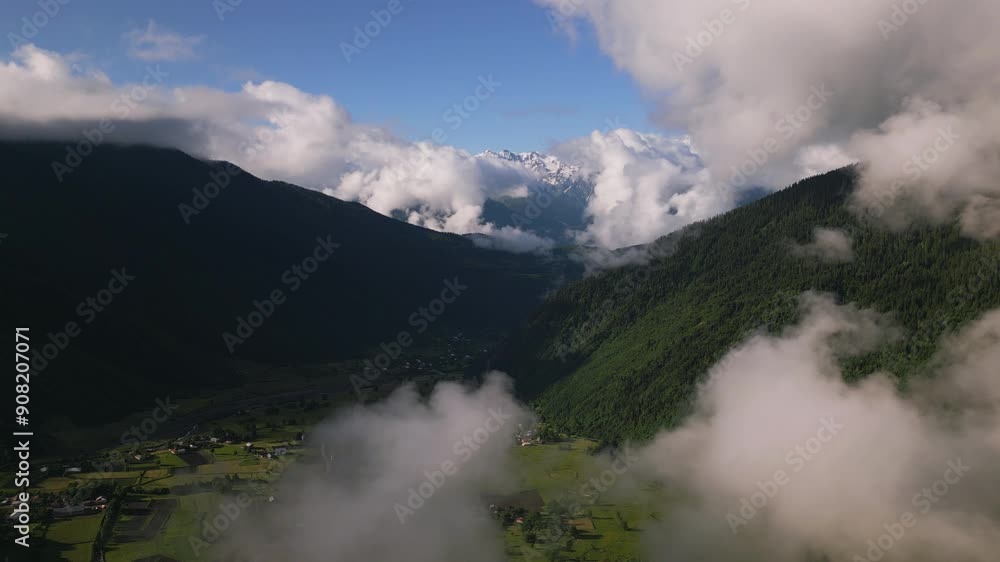 Aerial view of sunrise over Mazeri village in Svaneti mountains. Morning mist, green hills, snow-capped peaks in background. Rural landscape under soft early light. Drone shot Aerial view of sunrise over Mazeri village in Svaneti mountains. Morning mist, green hills, snow-capped peaks in background. Rural landscape under soft early light. Drone shot