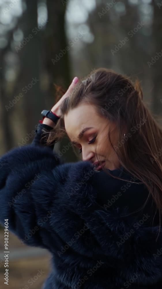 Attractive girl in the city park. Stylish woman in fur coat turning around and looking on camera outdoors. Slow motion. Vertical video Attractive girl in the city park. Stylish woman in fur coat turning around and looking on camera outdoors. Slow motion. Vertical video