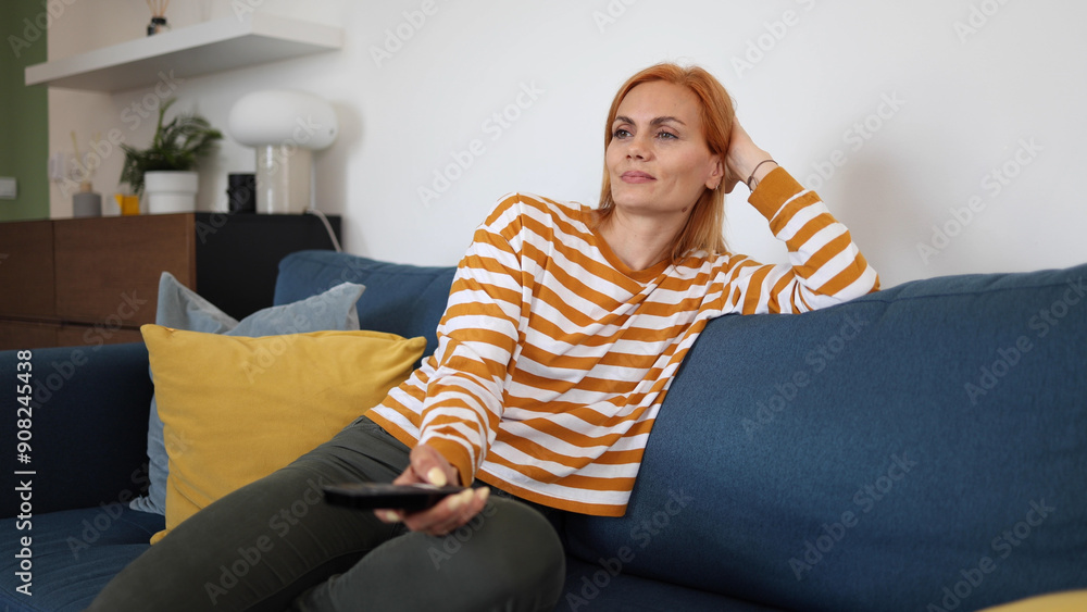 Woman relaxing on the couch and watching TV Woman relaxing on the couch and watching TV
