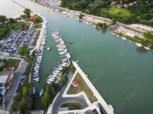 Aerial over Port Dalhousie with boats in Martindale Pond leading out to Lake Ontario alongside Lakeside Park in St. Catharines, Ontario, Canada on a summer afternoon in July, 2024.