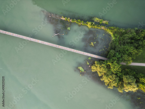 Aerial view looking down to a pedestrian bridge crossing Martindale Pond connecting Rennie Park and Royal Henley Park in St. Catharines, Ontario, Canada. Shot on a summer afternoon in July, 2024. photo