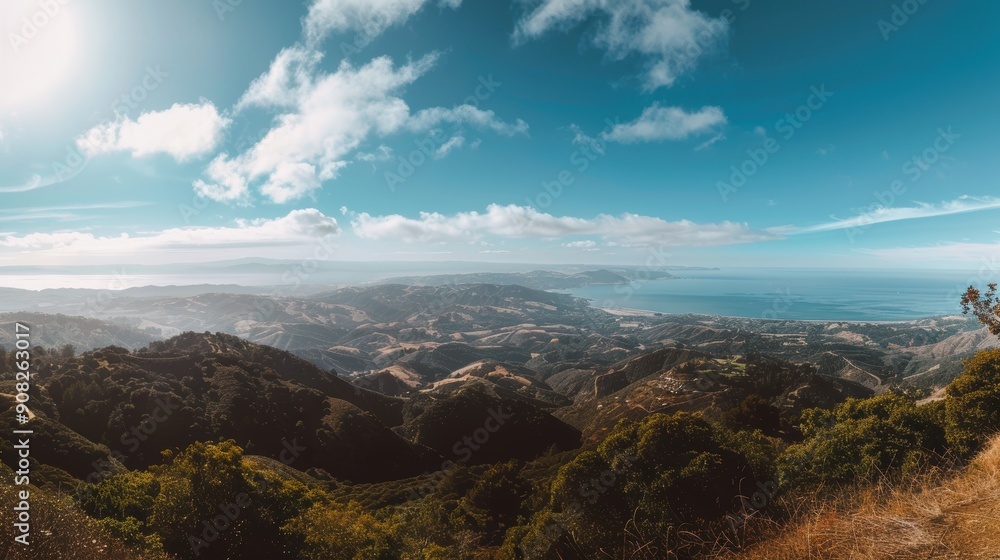 Scenic view of mountain landscape with ocean vista under partly cloudy sky Scenic view of mountain landscape with ocean vista under partly cloudy sky