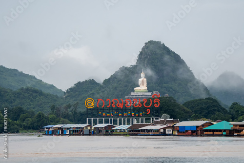 Kanchanaburi, Thailand A vibrant cluster of traditional Thai houseboats moored along the scenic Kwae Noi River near Skywalk Muang in Kanchanaburi, Thailand. Lush green mountains and fores photo