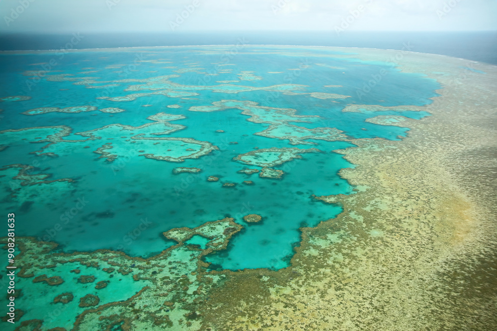 Aerial view of the Great Barrier Reef, the world's largest coral reef system located in the Coral Sea, off the coast of Queensland, Australia Aerial view of the Great Barrier Reef, the world's largest coral reef system located in the Coral Sea, off the coast of Queensland, Australia