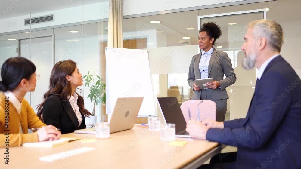 African American businesswoman is leading a business meeting in the boardroom at her company African American businesswoman is leading a business meeting in the boardroom at her company