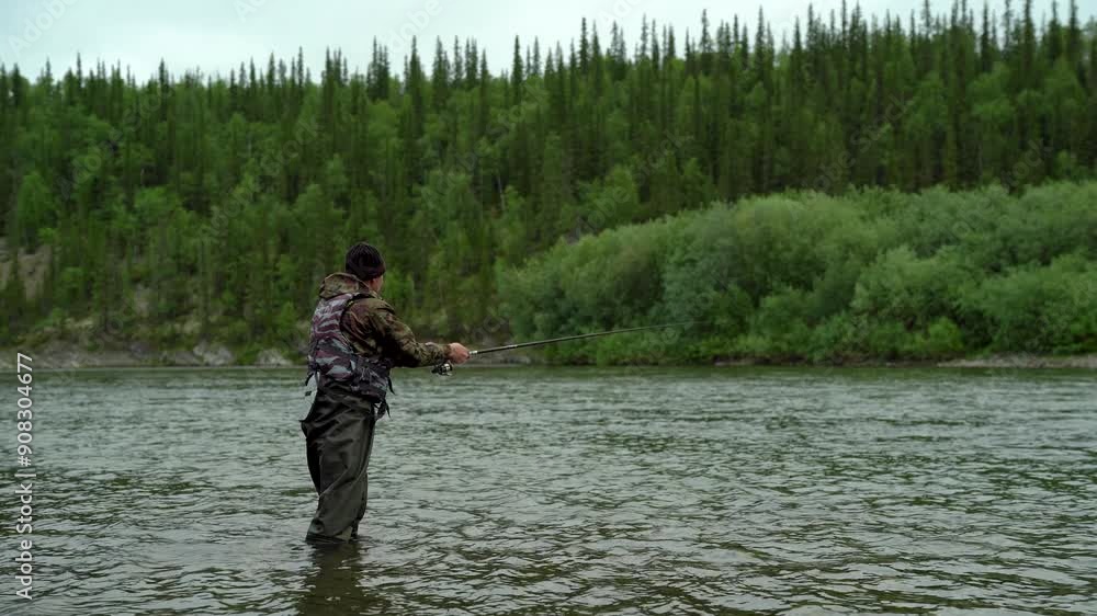 A fisherman casts a spinning rod to catch fish in a river near a forest A fisherman casts a spinning rod to catch fish in a river near a forest