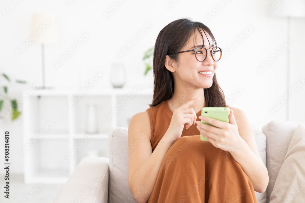 部屋でスマホを見る若い女性 部屋でスマホを見る若い女性