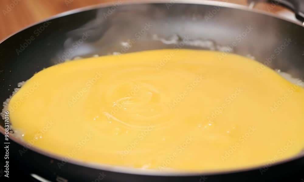 Golden Perfection: Fluffy omelet nearing completion in a non-stick pan, glistening with melted butter. Golden Perfection: Fluffy omelet nearing completion in a non-stick pan, glistening with melted butter.