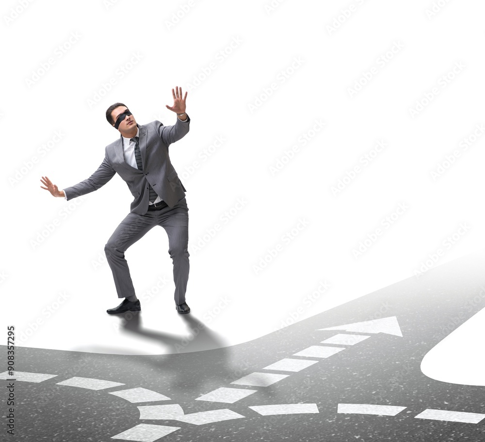 Young businessman at crossroads in uncertainty concept Young businessman at crossroads in uncertainty concept