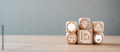 Wooden blocks with icons representing audit concepts such as compliance, risk management, and business analysis on a wooden table.