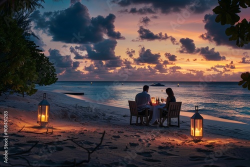 Romantic couple enjoying a candlelit dinner on the beach in the Maldives, with a beautifully set table and soft lanterns illuminating the scene. photo