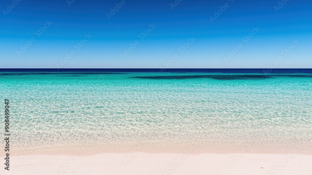 Fototapeta premium A tranquil beach features crystal-clear waters merging with the bright blue sky