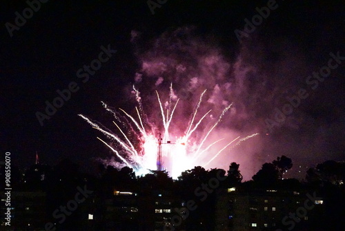 Fireworks illuminate night sky over silhouetted cityscape in Madrid, Spain