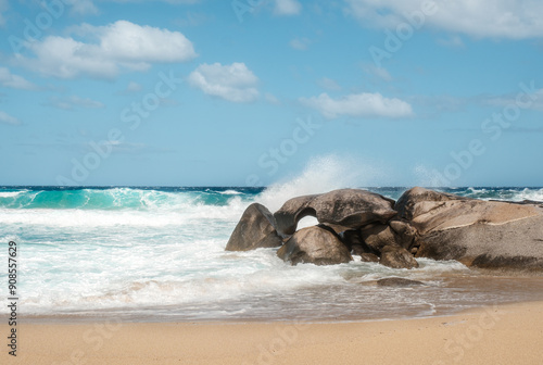Waves from the Mediterranean sea crash onto rocks and the sandy beach at Aregno Plage near Algajola in Corsica