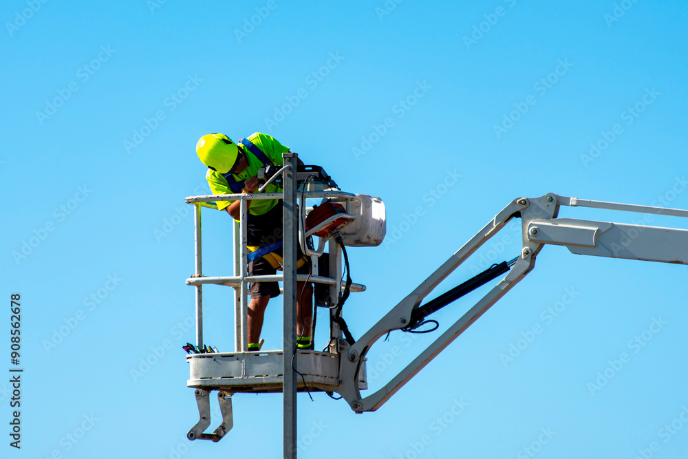 Electrician Working in a Boom Lift Electrician Working in a Boom Lift