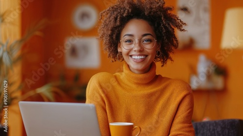 Happy Woman Smiling While Browsing Laptop in Monochromatic Orange Workspace