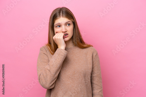 Teenager Russian girl isolated on pink background is a little bit nervous