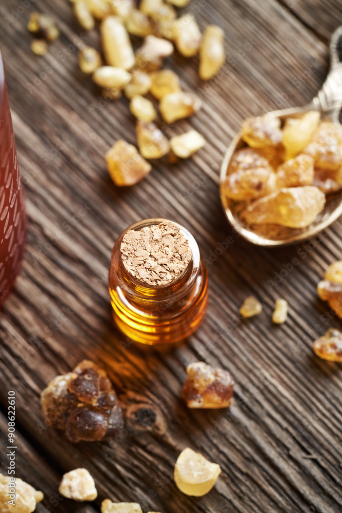 A transparent bottle of frankincense essential oil with boswellia resin A transparent bottle of frankincense essential oil with boswellia resin