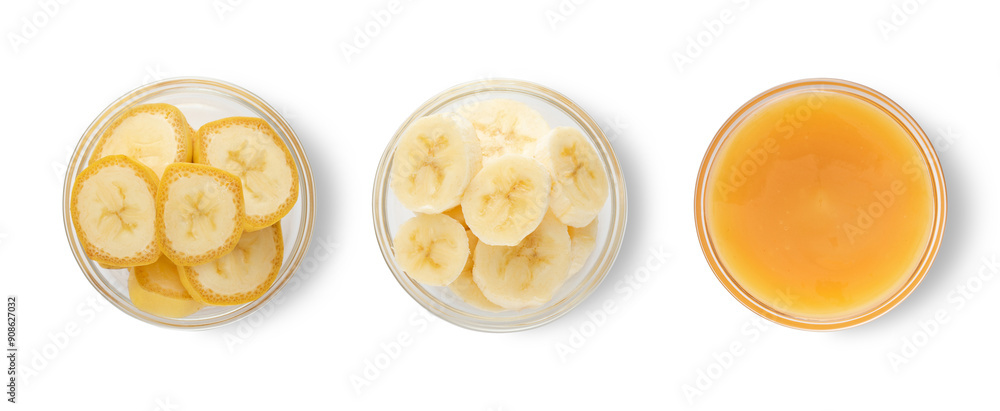 Raw ripe yelow banana slices with skin and mashed banana in glass bowls on white background.Top view.Macro. Raw ripe yelow banana slices with skin and mashed banana in glass bowls on white background.Top view.Macro.