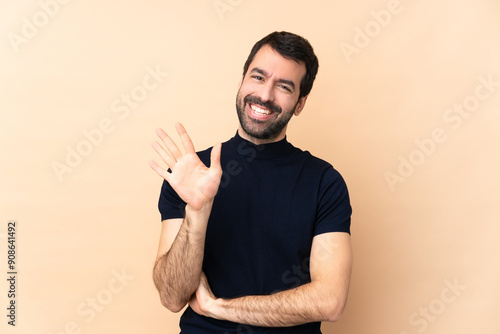 Caucasian handsome man over isolated background counting five with fingers