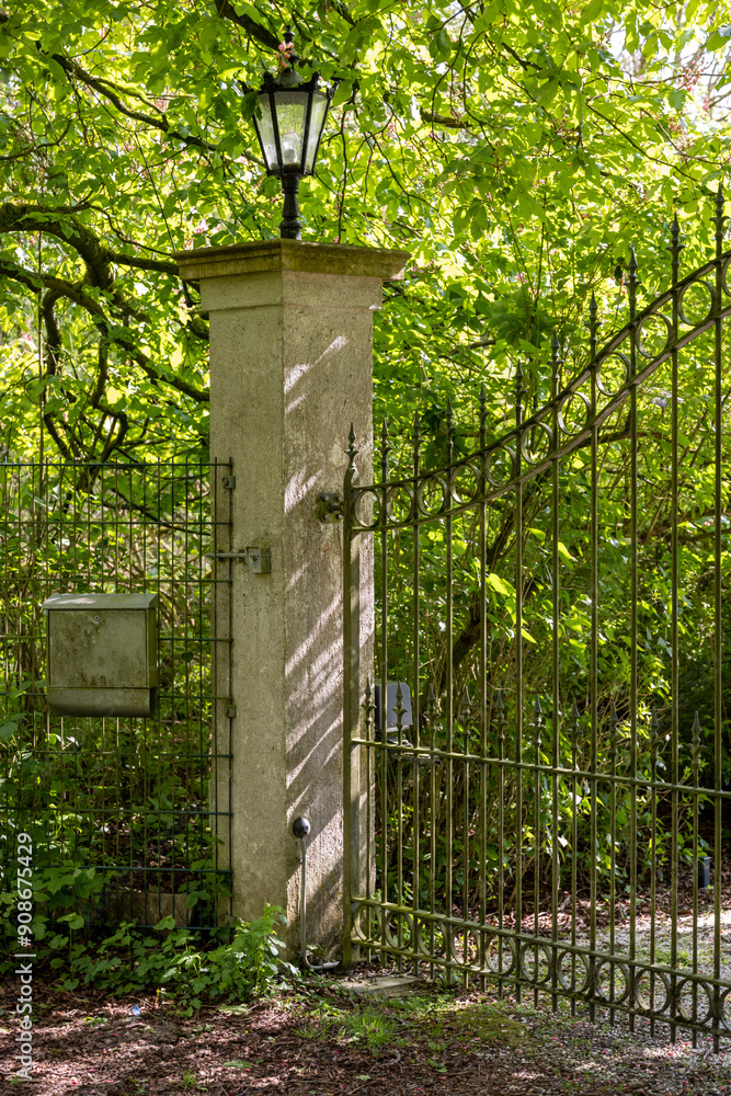 metal gates on brick columns in a park with dense trees
metal gates on brick columns in a park with dense trees