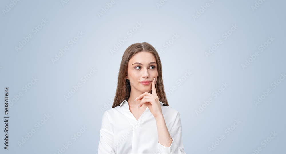 Thoughtful woman with a smile, touching her face, looking sidewa Thoughtful woman with a smile, touching her face, looking sidewa