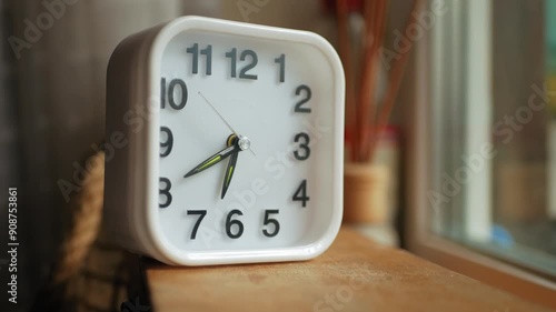 Small square shaped clock on a wooden box showing seventh or nineteenth hour of the day