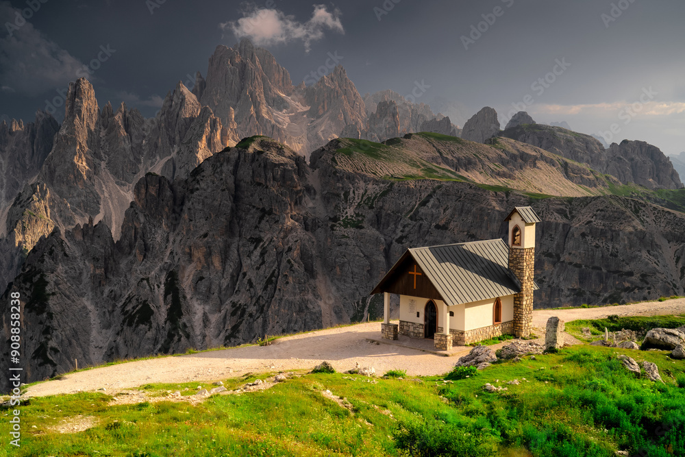 Capella Degli Alpini against the background of the peaks of Cadini di Misurina I of an approaching storm. This place is located near Rifugio Auronzo, province Belluno, Dolomites. Capella Degli Alpini against the background of the peaks of Cadini di Misurina I of an approaching storm. This place is located near Rifugio Auronzo, province Belluno, Dolomites.