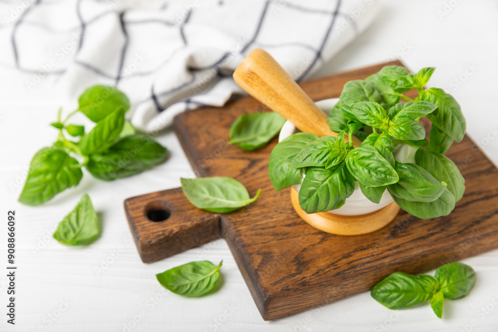 Fresh green basil in a mortar on a textured wooden background. Organic spices and herbs. Vegan. Fresh kitchen herbs. Fresh basil being made into pesto with mortar and pestle.Copy space. Place for text Fresh green basil in a mortar on a textured wooden background. Organic spices and herbs. Vegan. Fresh kitchen herbs. Fresh basil being made into pesto with mortar and pestle.Copy space. Place for text
