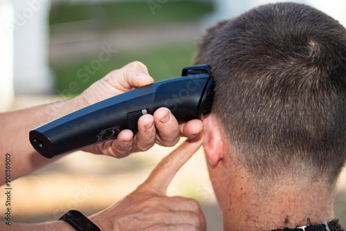A hairdresser cutting the hair of a dark-haired man. Close-up shots.