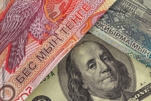 US $100 bill peeking out from under Kazakhstani tenge bills. Foreign exchange market. financial concept photo