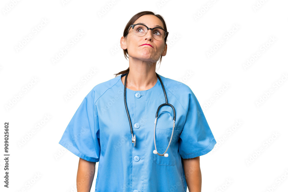 Middle-aged nurse woman over isolated background and looking up Middle-aged nurse woman over isolated background and looking up
