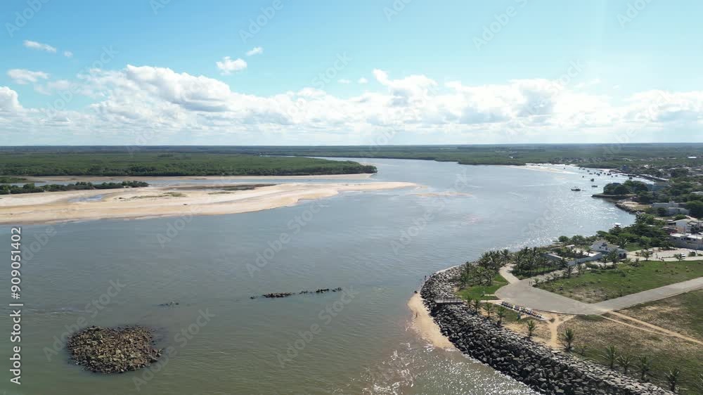 Imagem aérea de uma dia ensolarado na praia de Itaúnas no litoral do estado do Espírito Santo, na região tropical do Brazil. Com pessoas e crianças brincando na areia, restante na beira da praia.