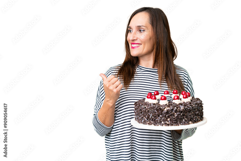 Middle age caucasian woman holding birthday cake over isolated chroma key background pointing to the side to present a product