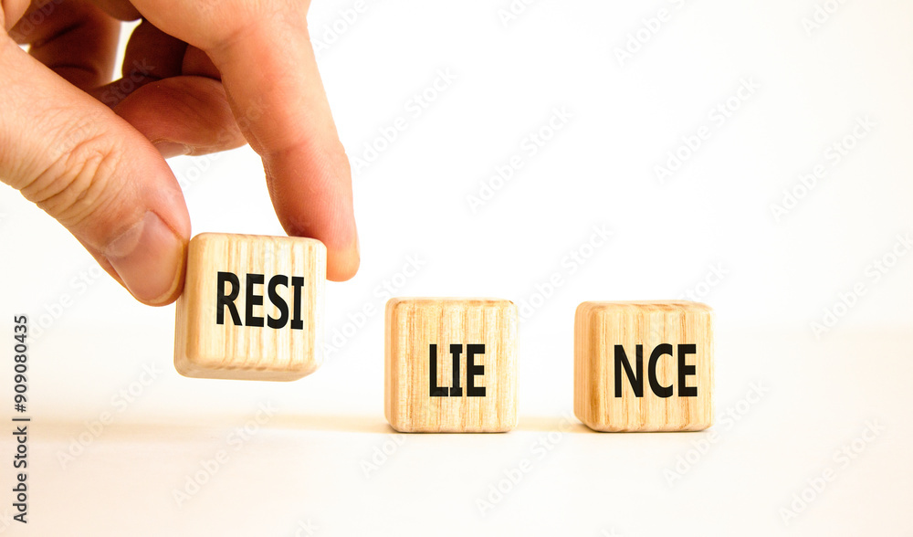 Resilience symbol. Concept word Resilience on beautiful wooden blocks. Businessman hand. Beautiful white background. Business resilience concept. Copy space. Resilience symbol. Concept word Resilience on beautiful wooden blocks. Businessman hand. Beautiful white background. Business resilience concept. Copy space.