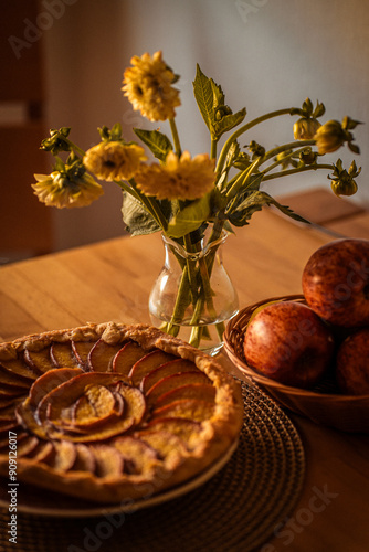 Still life with peach tart, ripe apples and yellow flowers - September mood