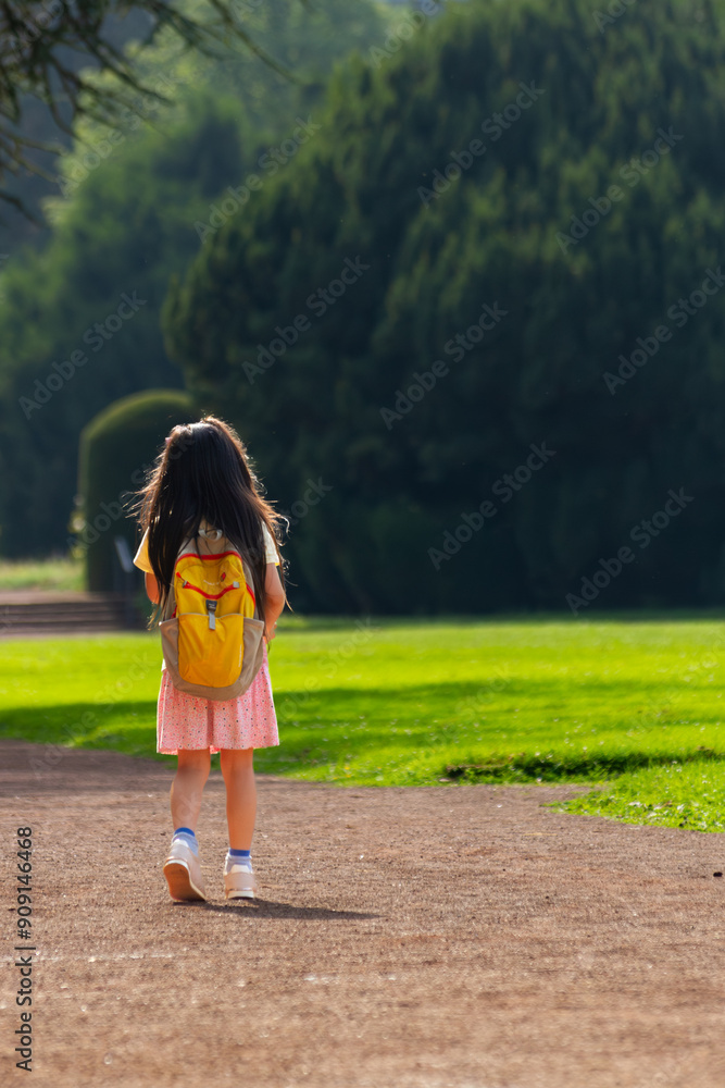Little Girl with Yellow Backpack Walking Outdoors Little Girl with Yellow Backpack Walking Outdoors