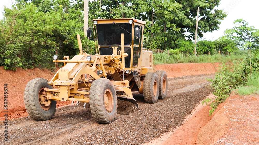 Image of gravels being leveled on a dirt road in preparation for asphalt paving for new road construction. Image of gravels being leveled on a dirt road in preparation for asphalt paving for new road construction.