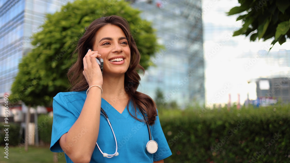 Beautiful, young female doctor enjoying outdoors and talking on mobile phone Beautiful, young female doctor enjoying outdoors and talking on mobile phone