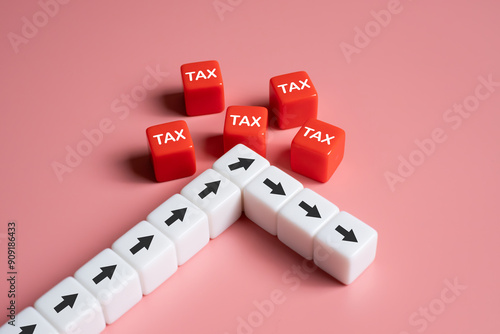 arrow turn down decreasing after engage with red cube tax. Tax expense management concept for business or individual who have high income. Pay tax and revenue decrease. Financial tax planning. photo