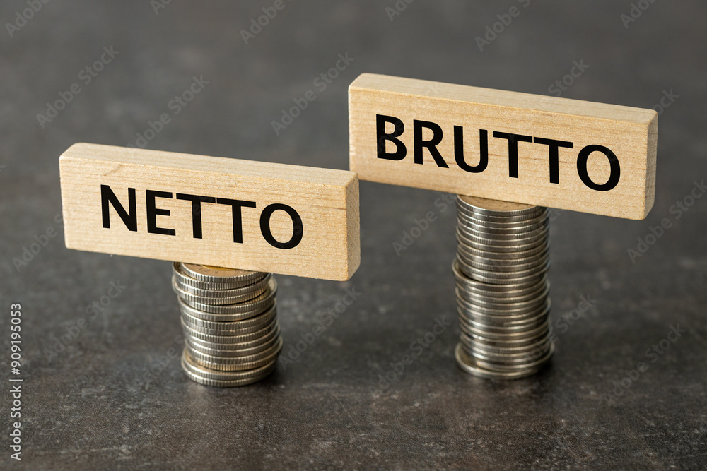 Netto and brutto. Net and gross symbol. Words on wooden cubes set on smaller and larger stack of coins change net to gross. Financial concept, dark wooden background, copy space