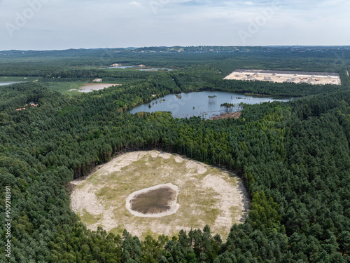 Aerial drone view of flooded sand pit. Forest submerged in a lake. Sunken sandpit with clear water.Lake District, swallow hole flooded as a result of the mining damage Pomorzany mine in Olkusz,Poland