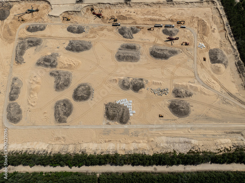 Aerial drone view of a sand mine in the forest. Loader Loading Sand Into Dump Truck In Sand Pit. Quarrying sand. Machines and truck working on sand mine. Mining quarry open pit excavation sand mine. photo