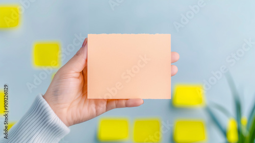 Hand Holding a Blank Card in Front of Colorful Background. The Image Captures a Close-Up of a Hand Grasping a Card for Creative and Informative Use