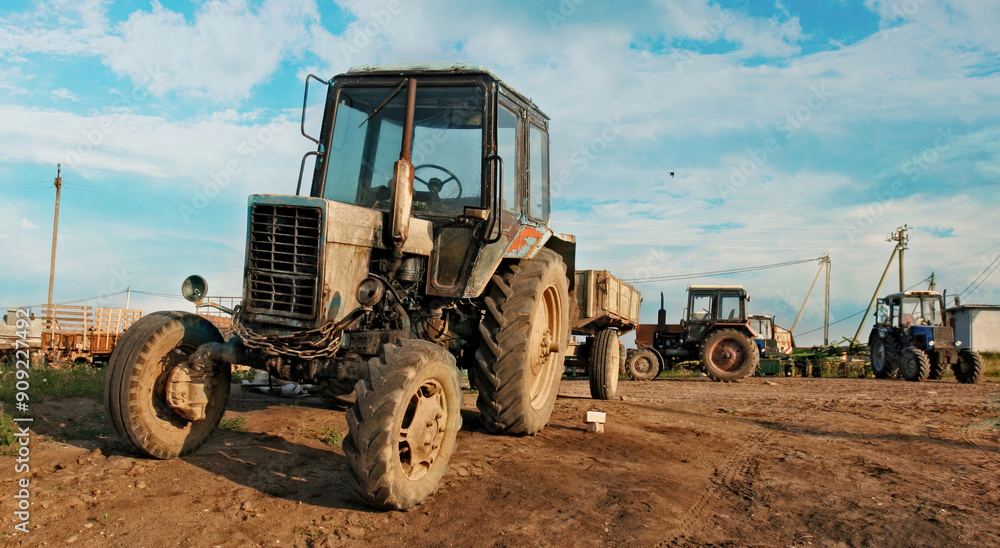 A Worn Tractor Stands Tall on a Sunny Day in Rural Russia A Worn Tractor Stands Tall on a Sunny Day in Rural Russia