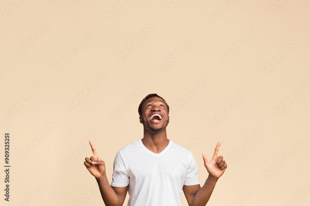 Look There. Afro Man Pointing Fingers Up At Empty Space Standing On Yellow Background. Studio Shot Look There. Afro Man Pointing Fingers Up At Empty Space Standing On Yellow Background. Studio Shot