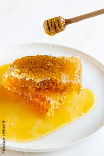 Close-up taken of sliced, natural honey with wooden honey stick